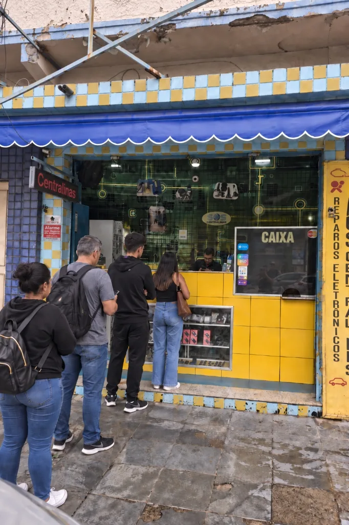 Balcão da SOS Centralinas no Centro de Nova Iguaçu, com clientes sendo atendidos